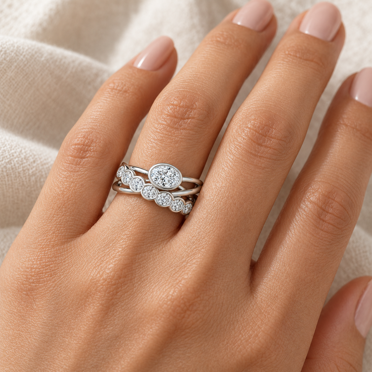 Oval & Round Bezel Crossover Ring in 14K white gold worn on hand – illustrative rendering, approximate scale