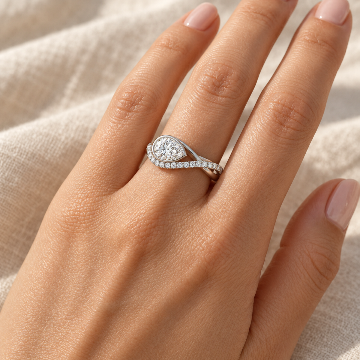 Pear Bezel Wave Ring in 14K white gold worn on hand – illustrative rendering, approximate scale