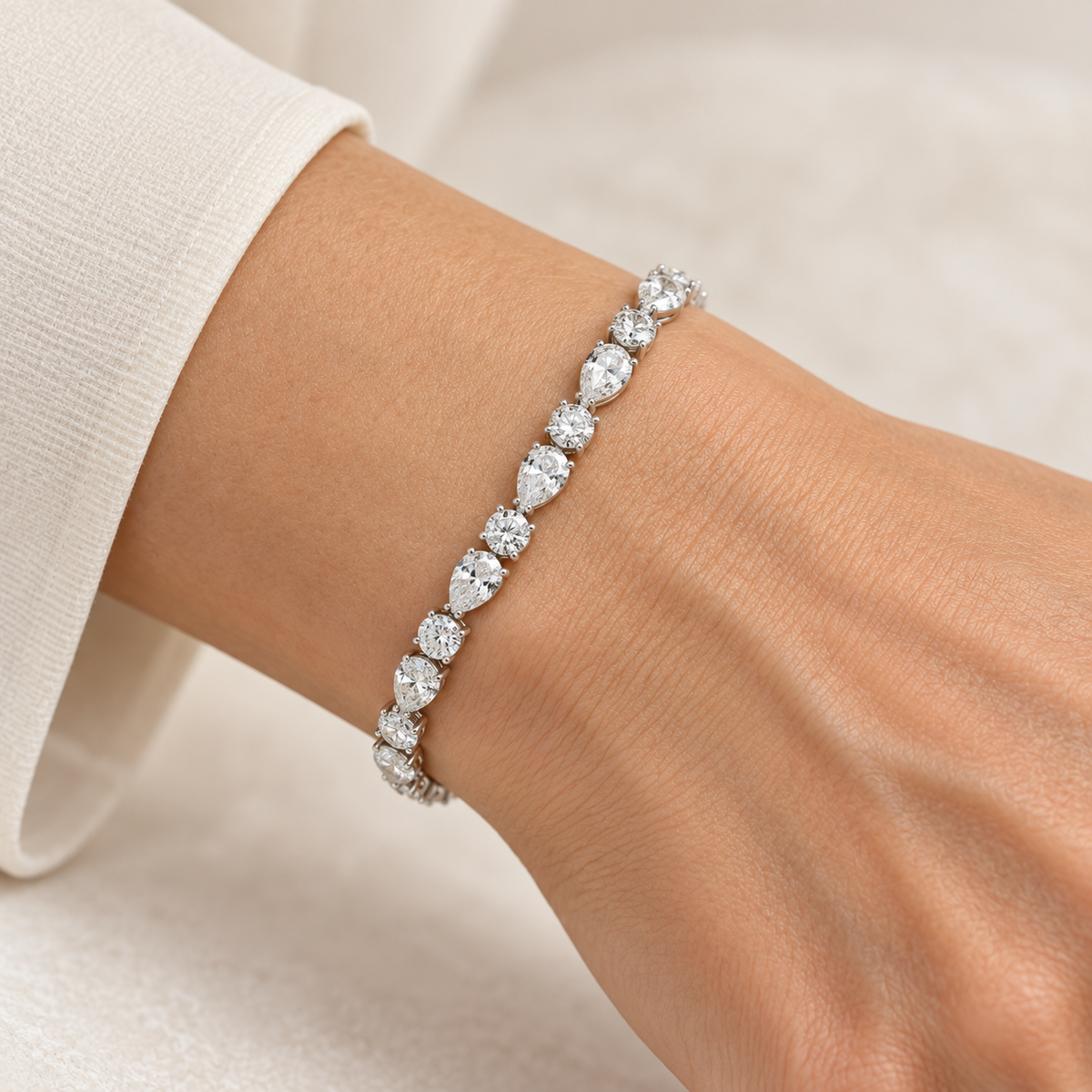 Round & Pear Alternating lab-grown diamond bracelet in 14K white gold, styled on a wrist — illustrative design rendering
